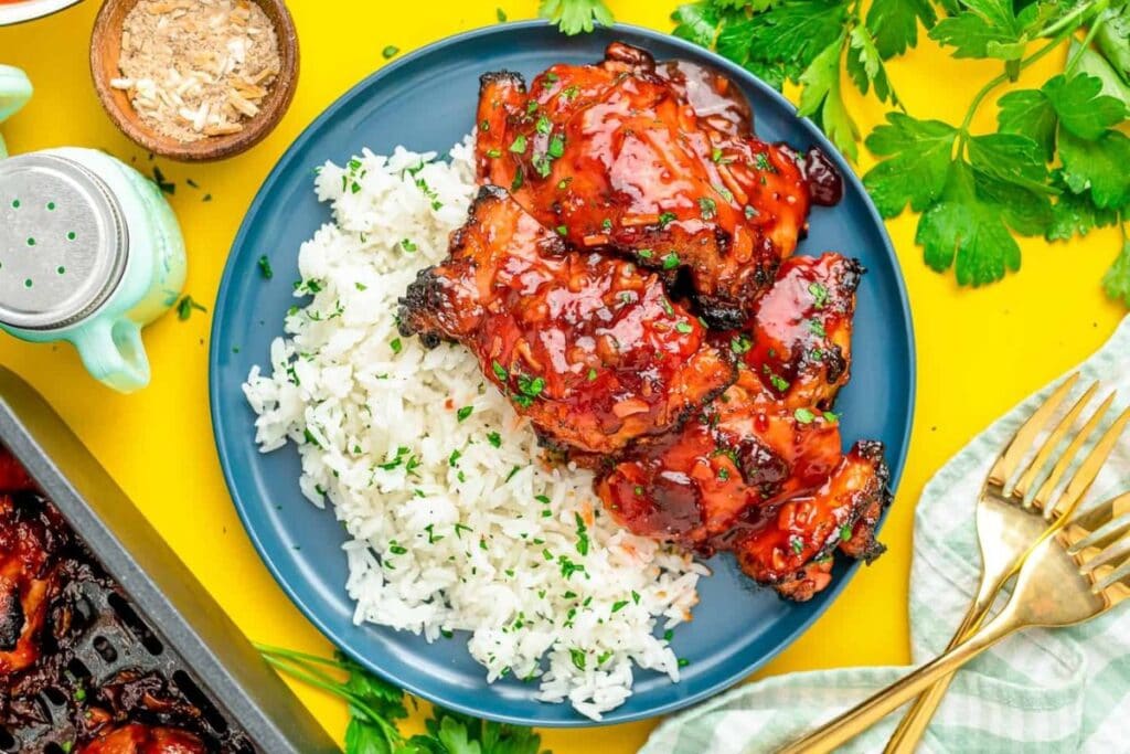 Overhead view of cranberry chicken with rice on a blue plate.