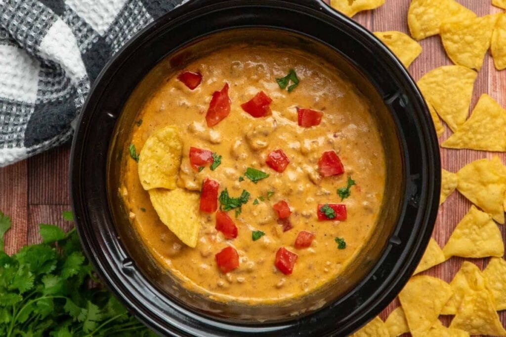 Crockpot cheeseburger dip with diced tomatoes, cilantro, and tortilla chips.