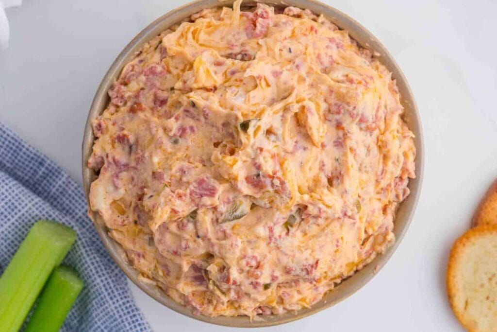 Overhead shot of reuben dip with celery sticks and toasted bread slices.