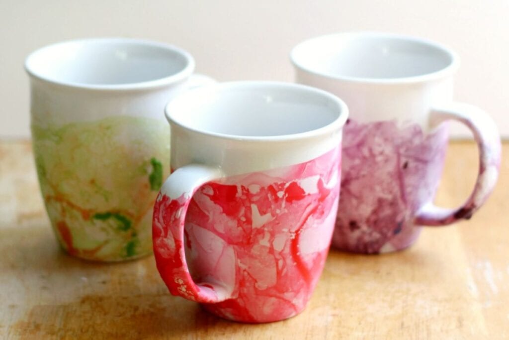 A close up shot of DIY marbled nail polish mugs.
