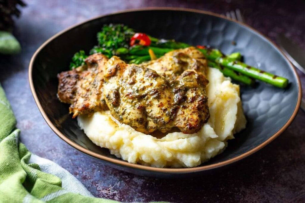 Chicken thighs with dill sauce over mashed potatoes and grilled broccoli.