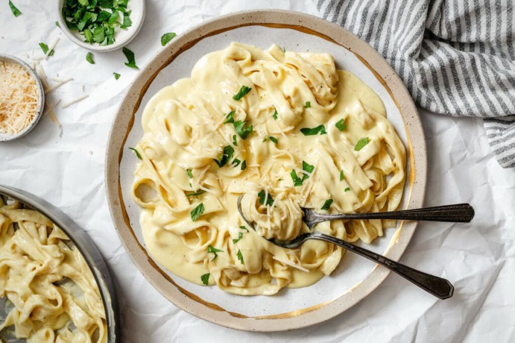 Overhead shot of fettuccine alfredo on a plate with parsley and parmesan.