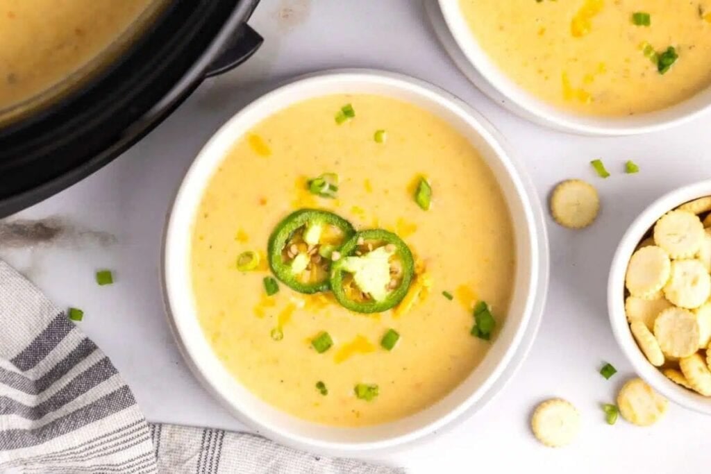 Overhead shot of jalapeno cheddar potato soup with crackers and green onions.