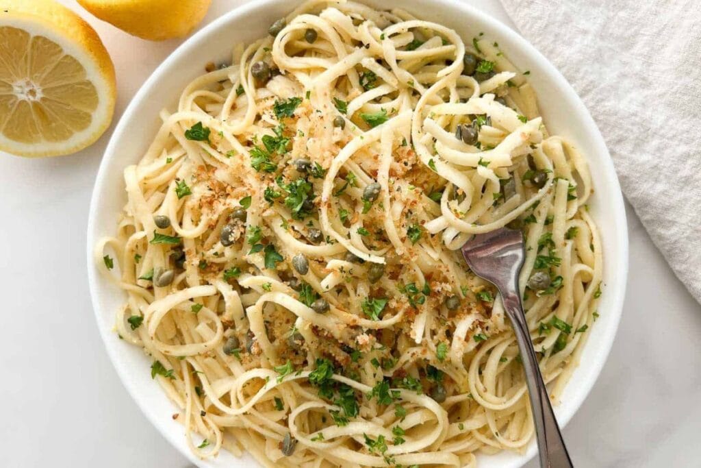 Overhead shot of lemon caper pasta with parsley and breadcrumbs in a bowl.