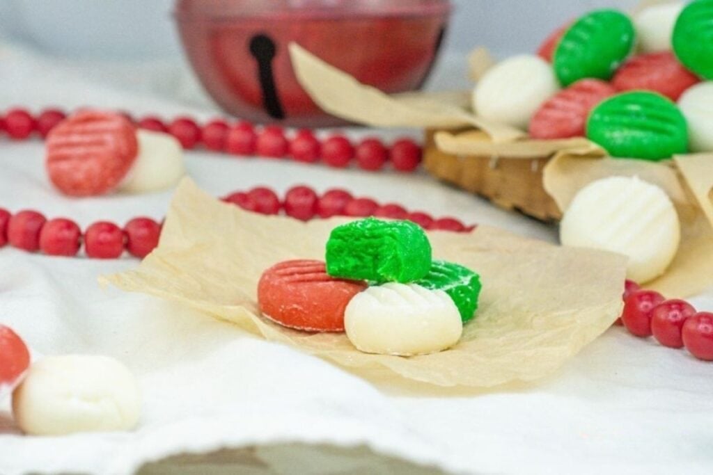 Red, green, and white peppermint cream cheese candies with Christmas decorations.