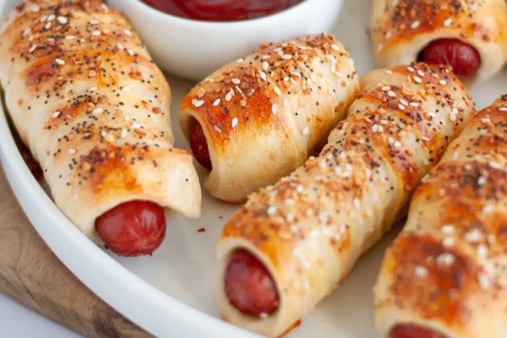 Pigs in a blanket with everything bagel seasoning served with ketchup.