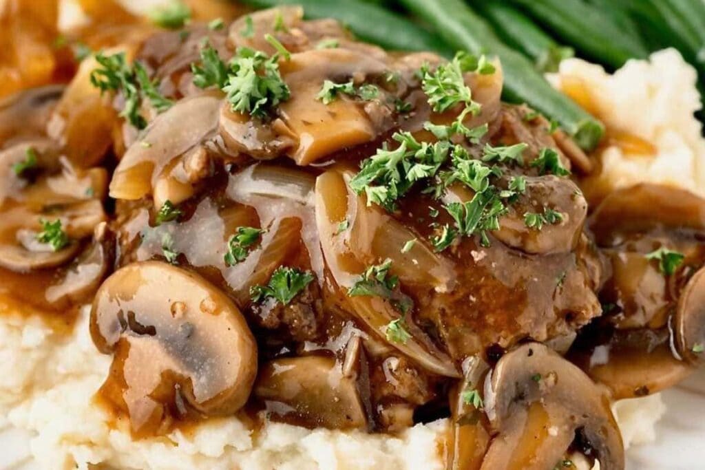 Salisbury steak with mushroom gravy, mashed potatoes, and green beans.