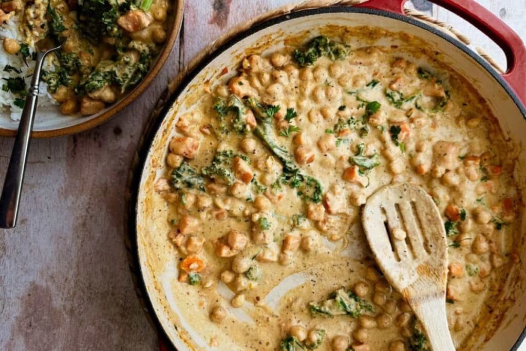 Overhead shot of sweet potato and chickpea curry with kale in a pan.