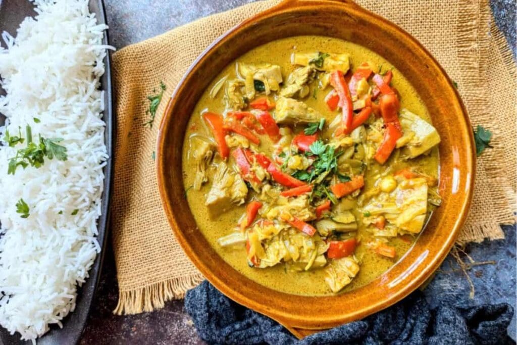 Overhead shot of Thai jackfruit curry with red peppers and a side of white rice.
