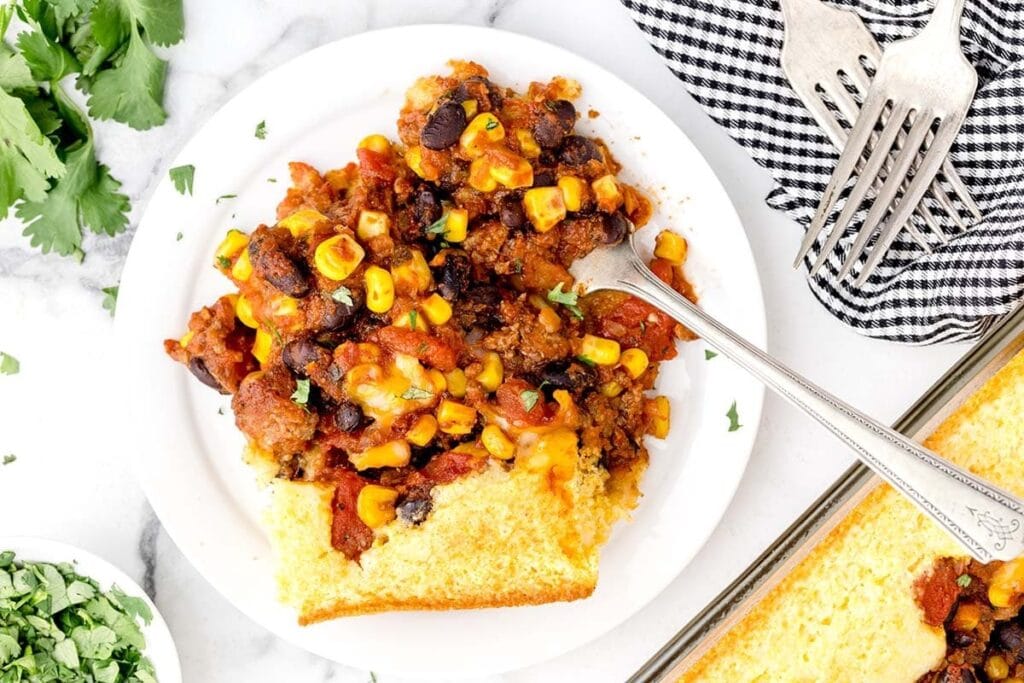 Chili cornbread casserole served on a white plate.
