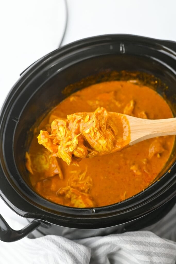 Chunks of butter chicken in a rich sauce inside a crockpot.