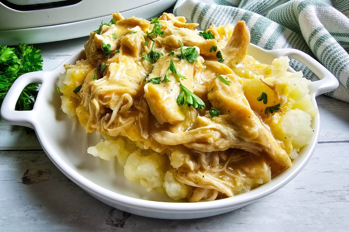 Shredded chicken and gravy served over mashed potatoes with parsley.