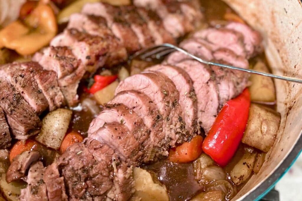 Close-up view of pork tenderloin in a skillet.