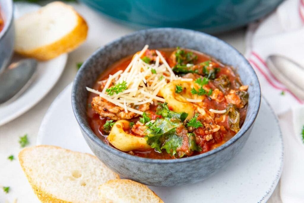 Sausage tortellini soup with kale served in a bowl.