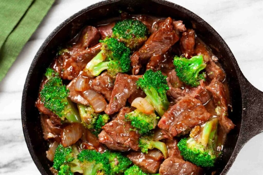 Beef and broccoli stir fry in a skillet.