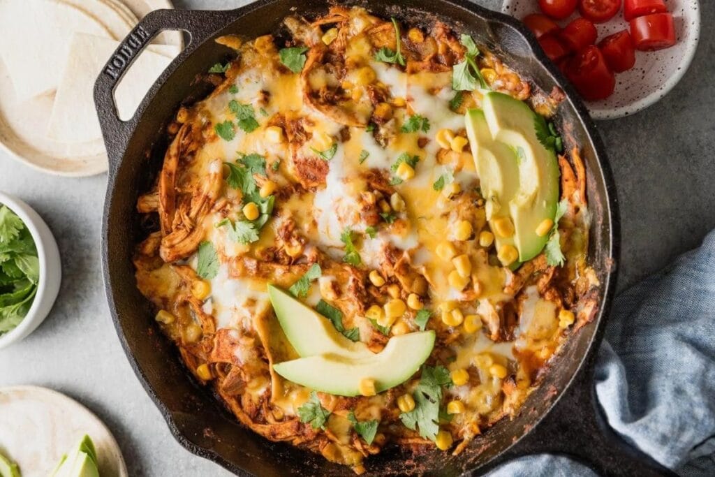 A close up shot of chicken enchilada skillet with corn.