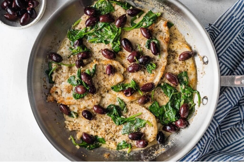 A close up shot of chicken with olives.