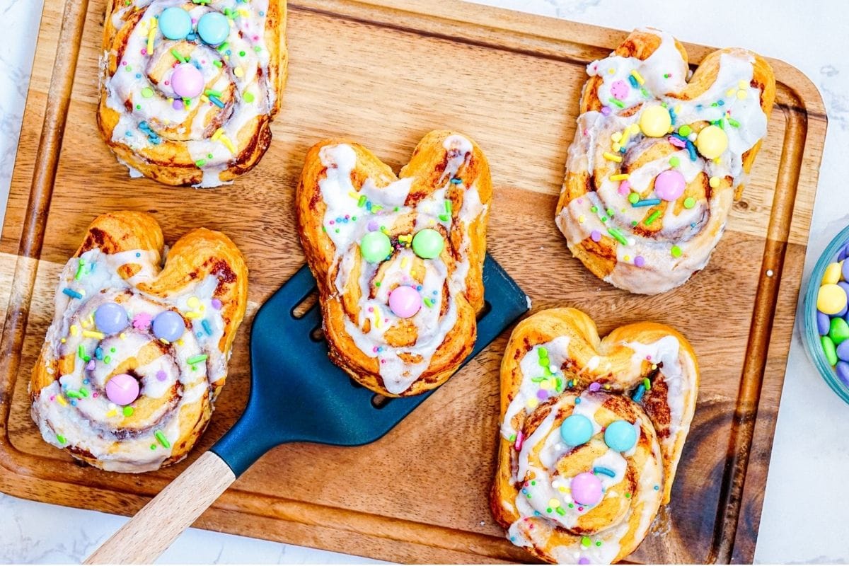 Bunny cinnamon rolls on a wooden board.