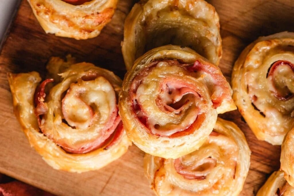A close up shot of ham and cheese puff pastry pinwheels.