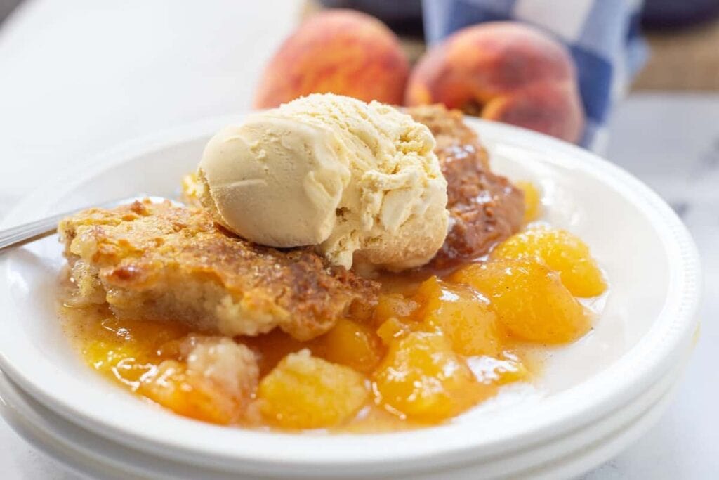 A close up shot of Homemade Peach Cobbler with Fresh Peaches.