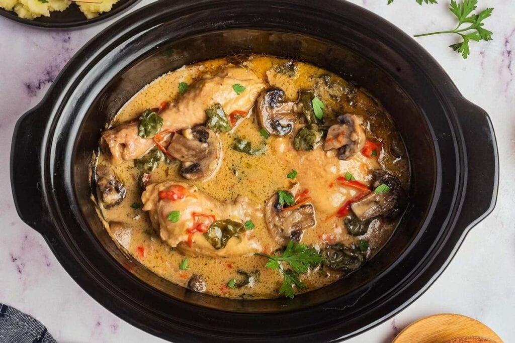 A close up shot of slow cooker creamy chicken and mushrooms.