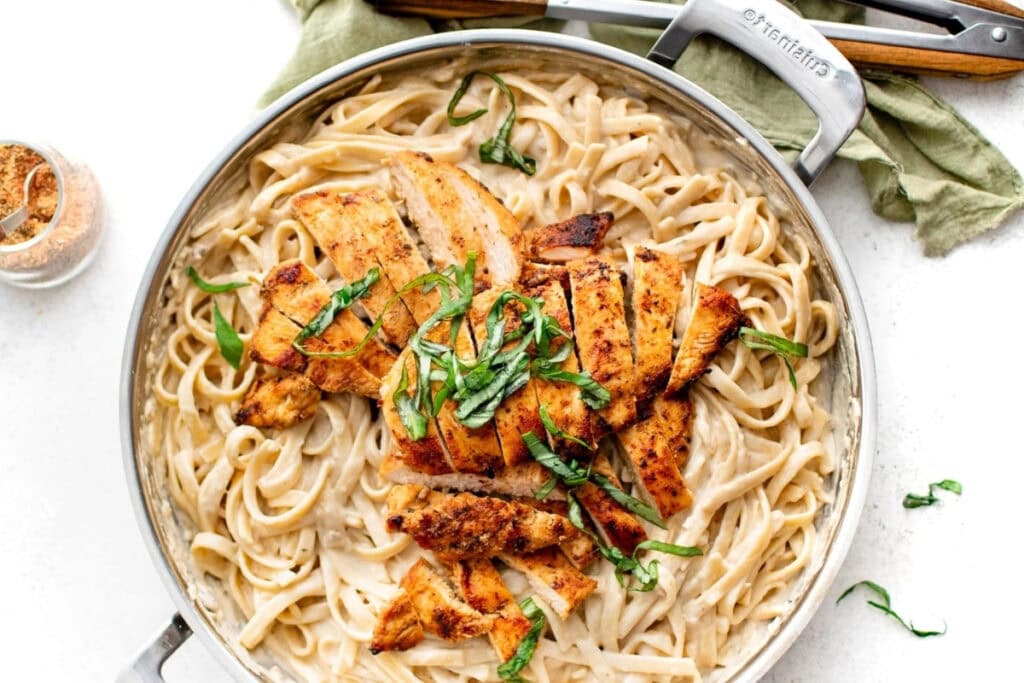 Blackened chicken alfredo in a skillet.