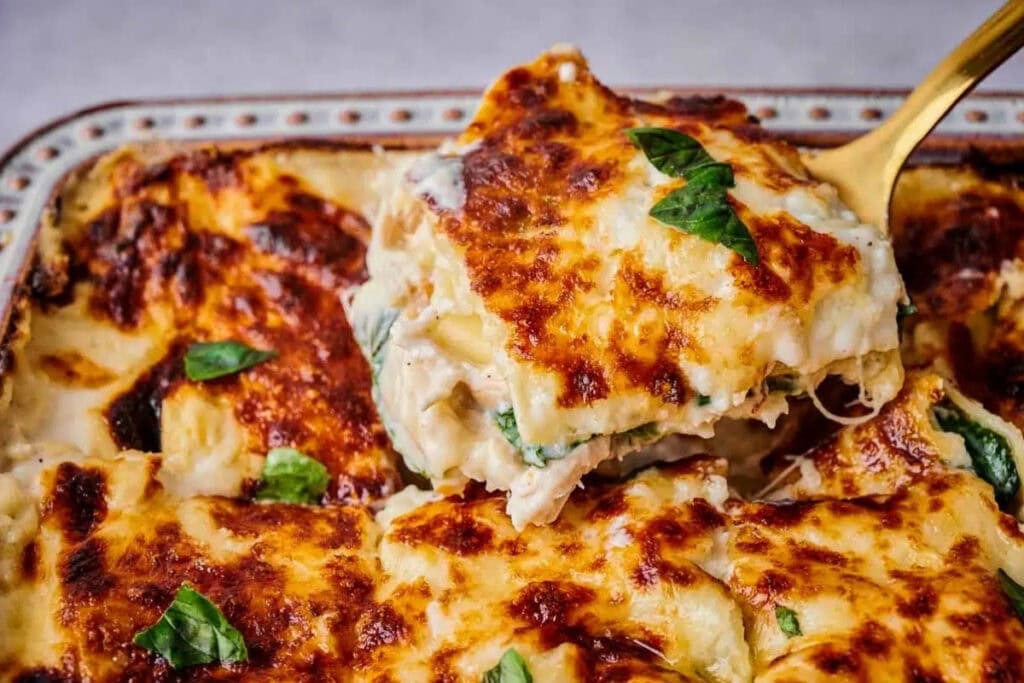 Chicken alfredo lasagna close-up on a spatula.