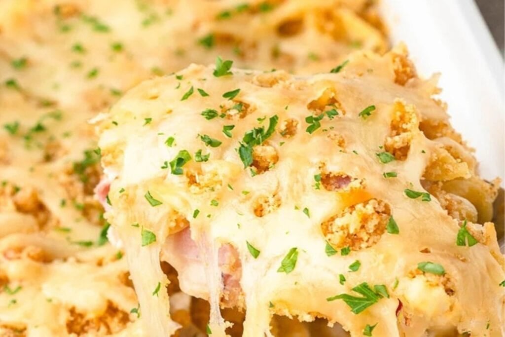 Close-up of chicken cordon bleu casserole on a spoon.