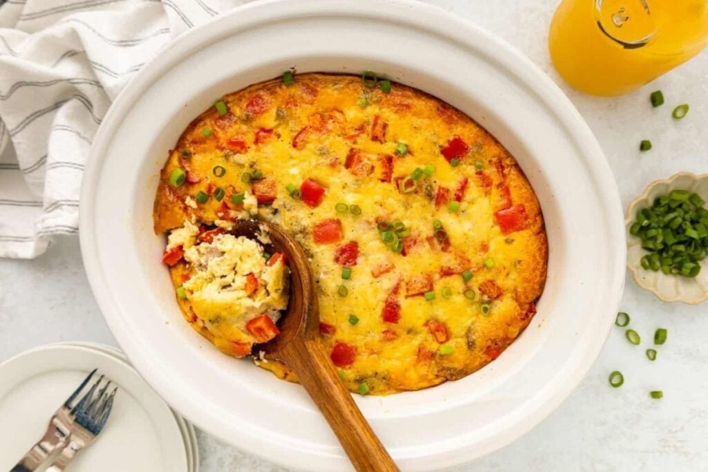 Crockpot breakfast casserole with eggs, peppers, and cheese in a slow cooker.