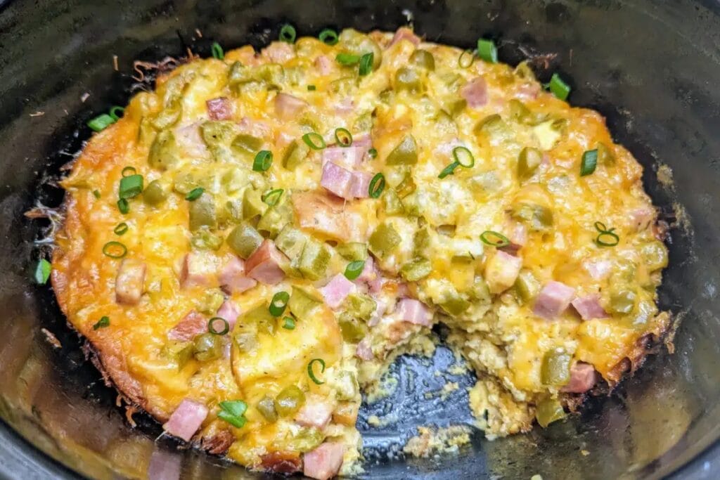 Crockpot Denver omelet casserole with ham, peppers, and cheese in a slow cooker.