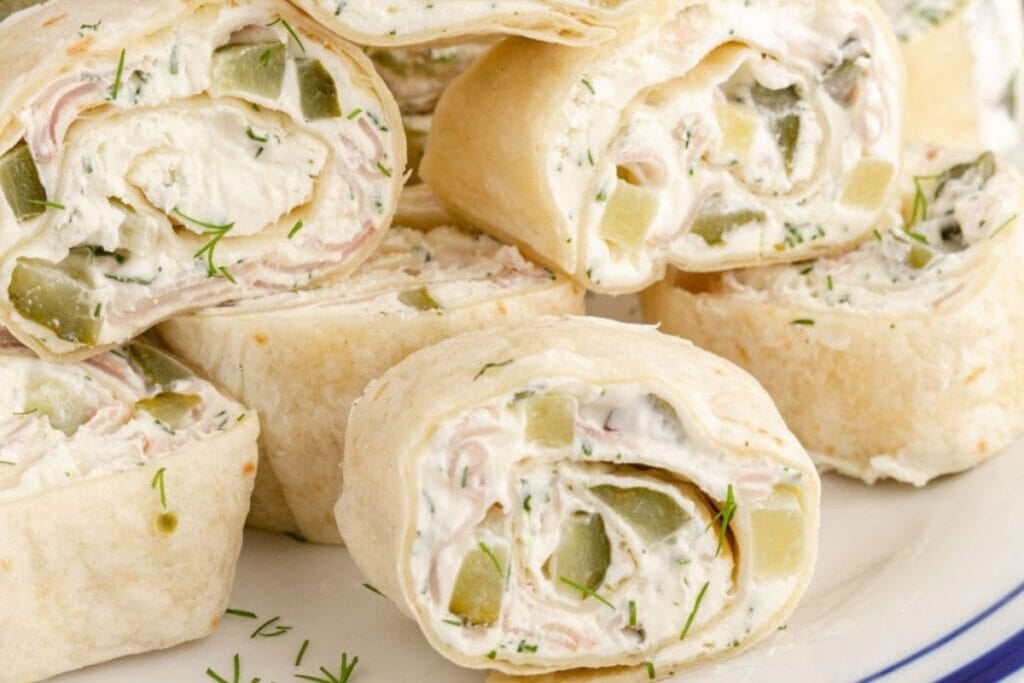 Close-up of dill pickle pinwheels on a plate.