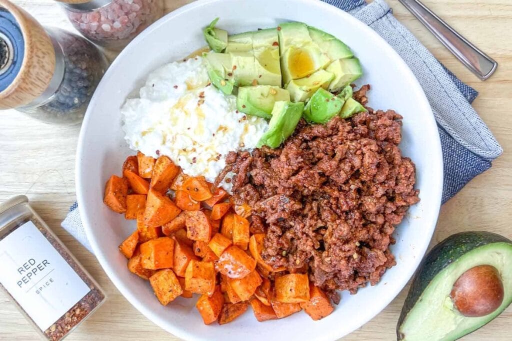 Ground beef, sweet potatoes, and avocado in a bowl.