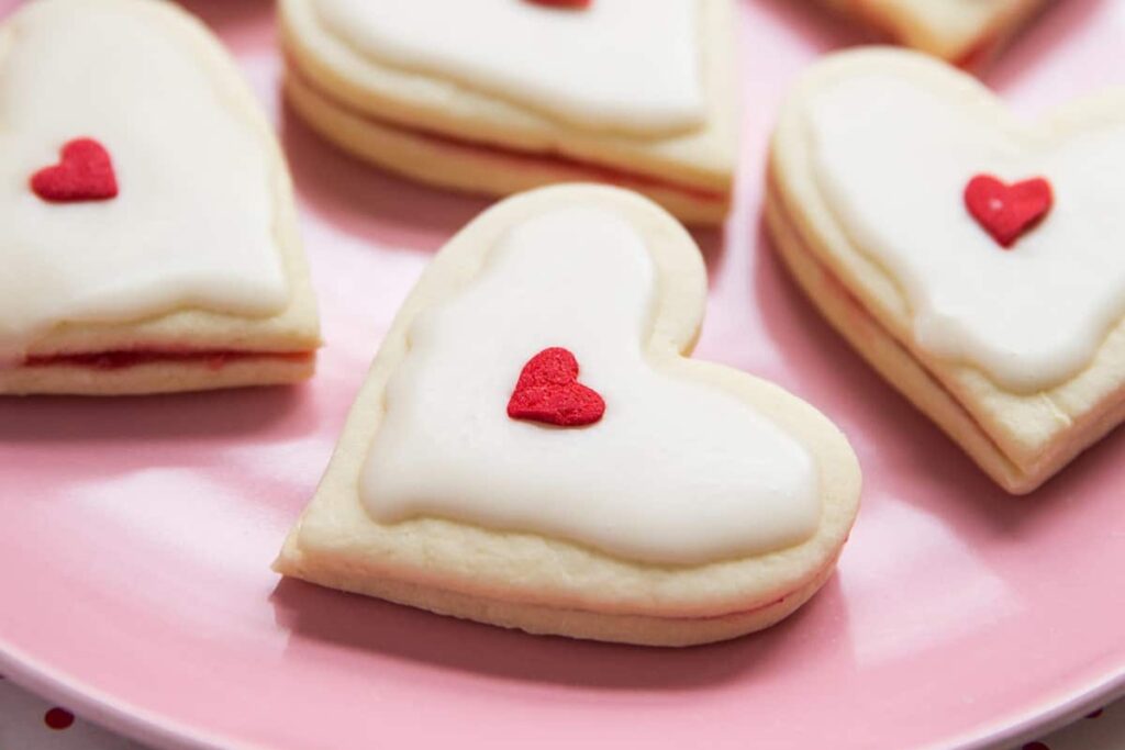 Heart shaped empire biscuits on a plate.