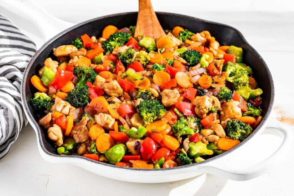 Honey garlic chicken and broccoli stir fry in a skillet.