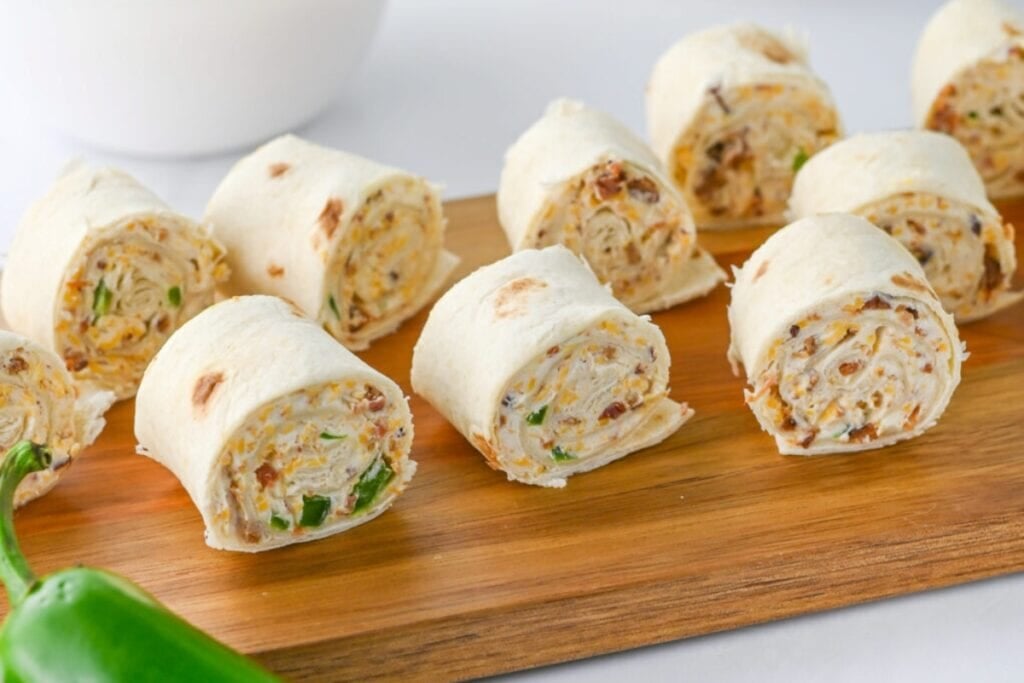 Jalapeño popper pinwheels on a wooden board.