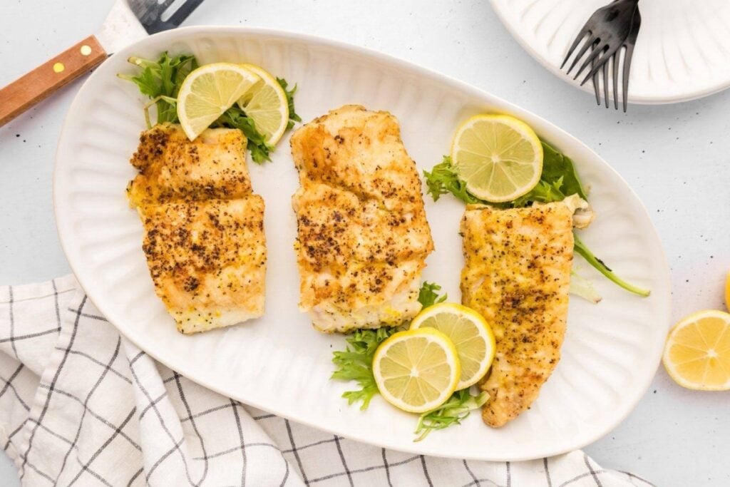 Lemon pepper fish on a plate.