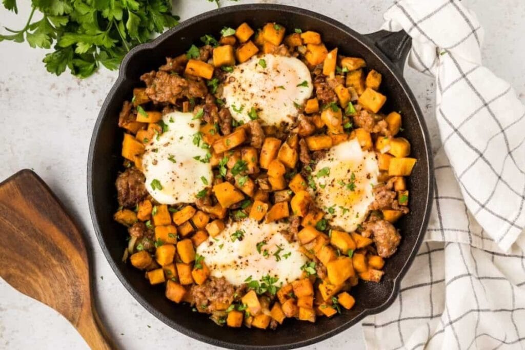 Overhead view of low-carb sweet potato breakfast with a poached egg in a skillet.