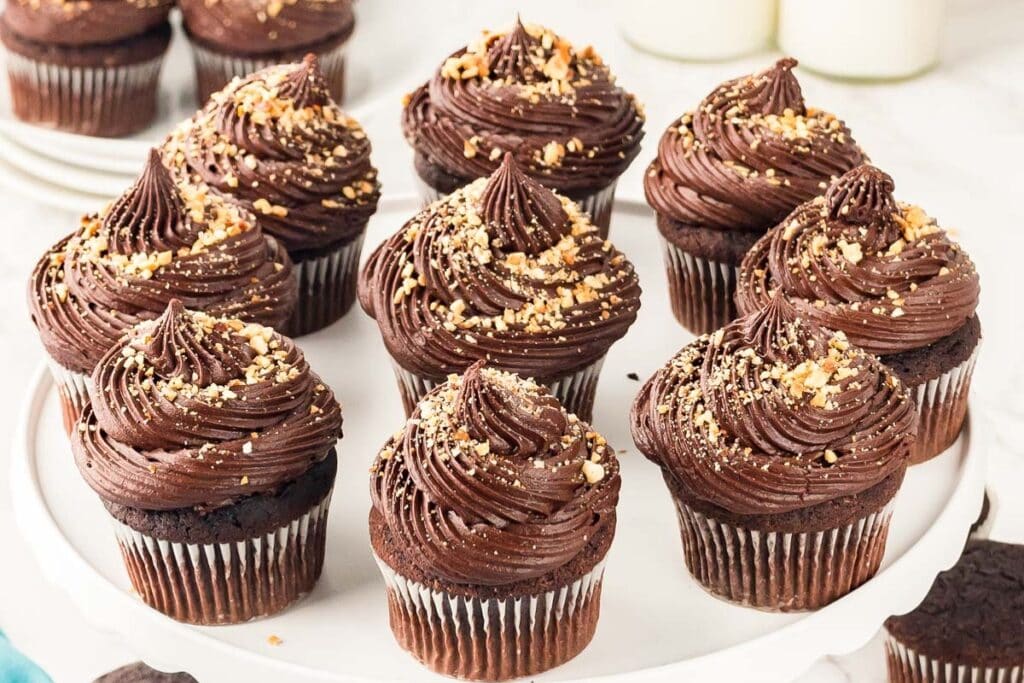 Nutella cupcakes topped with chocolate frosting and chopped nuts.