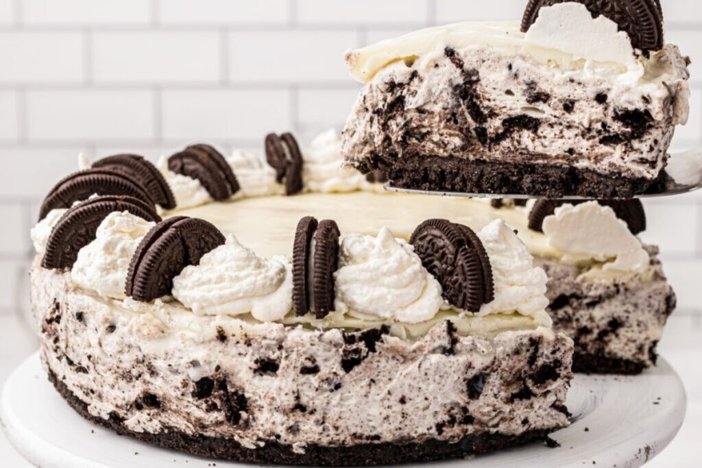 Oreo cheesecake topped with whipped cream and chocolate sandwich cookies.