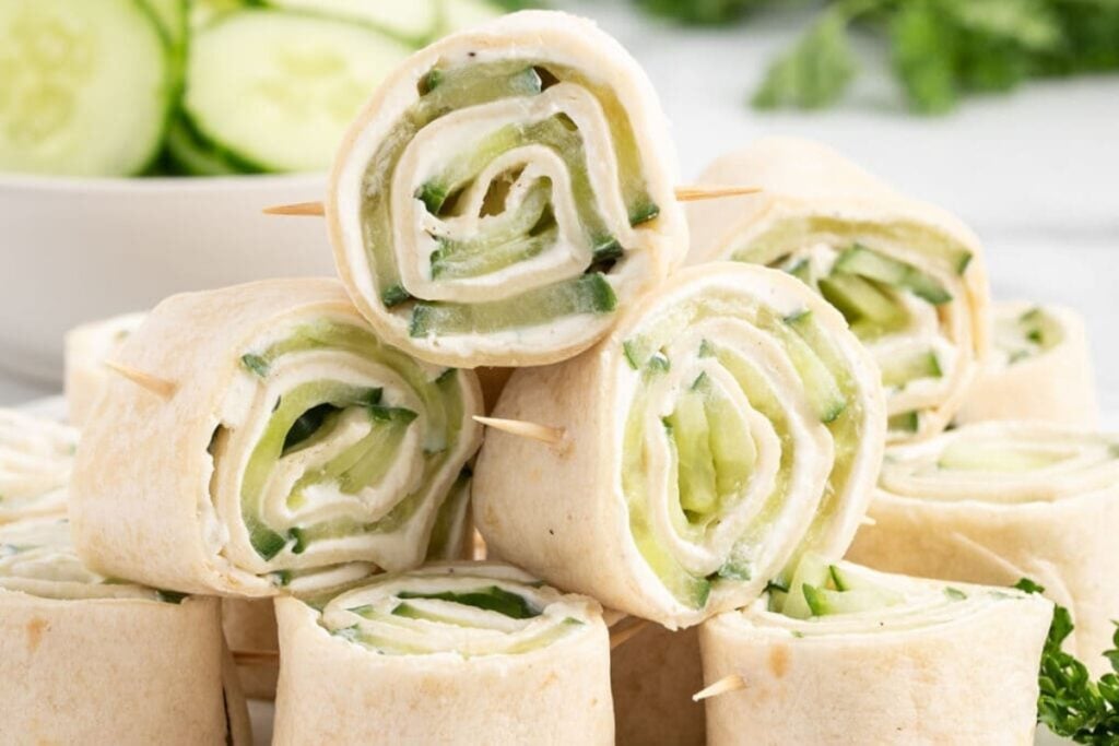 Close up of pinwheel sandwiches stacked on a plate.