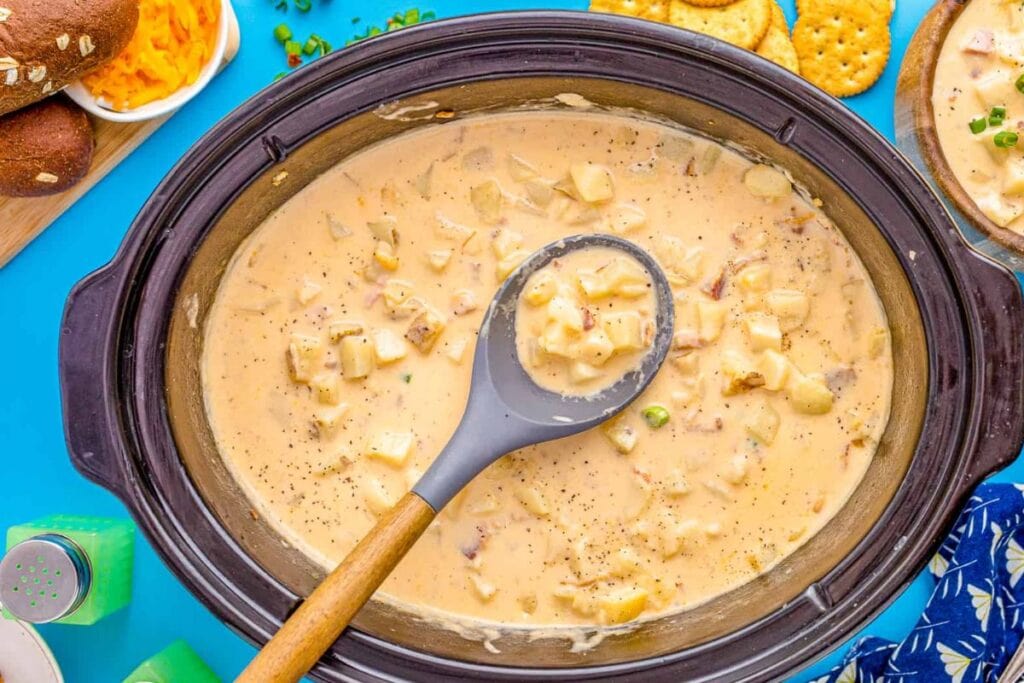 potato soup in a black crockpot with spoon