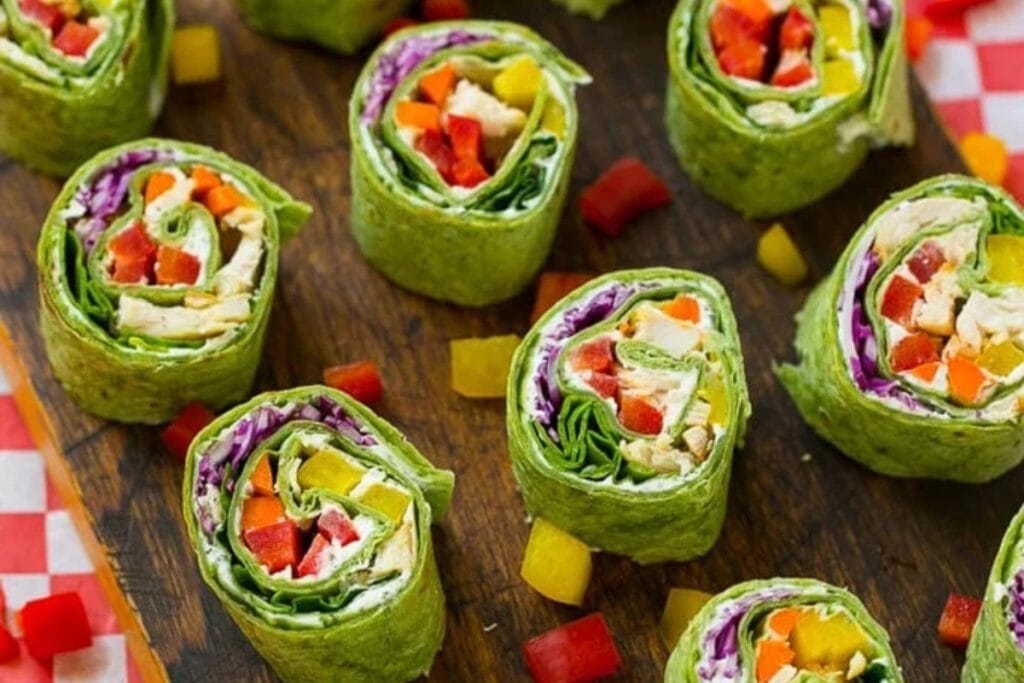 Rainbow veggie pinwheels on a wooden board.