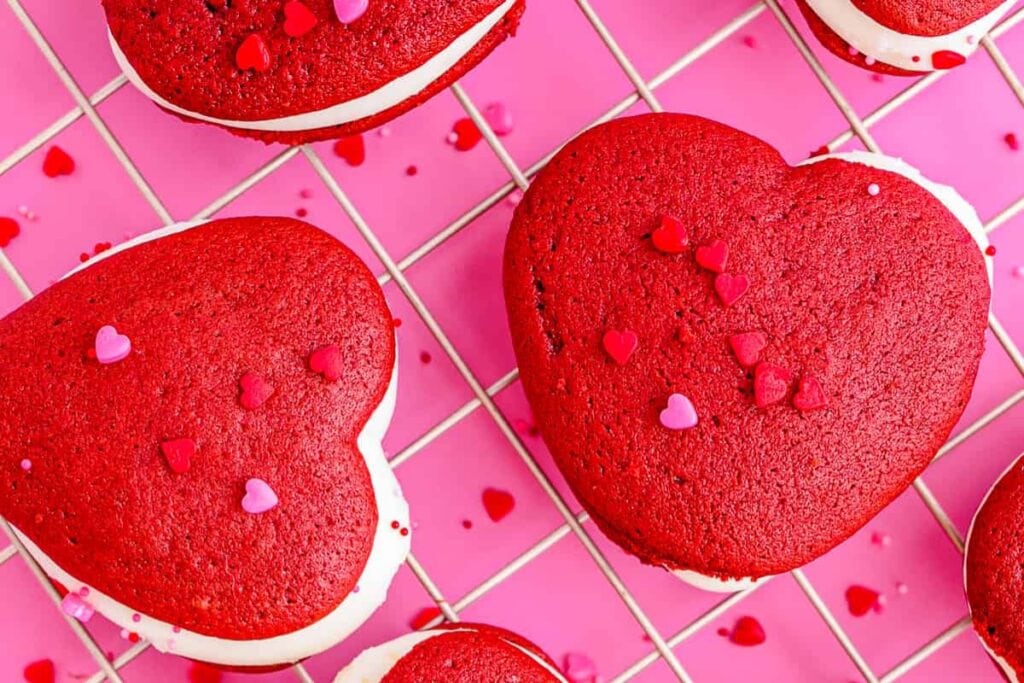 Red velvet whoopie pies on a cooling rack.