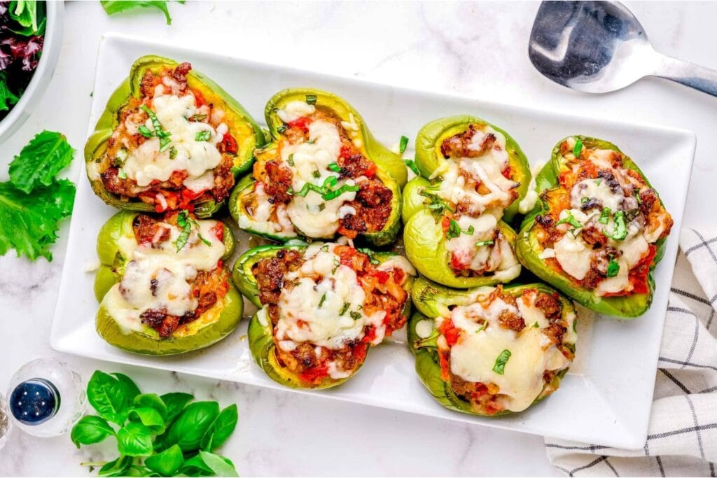 Sausage stuffed peppers on a rectangular plate.