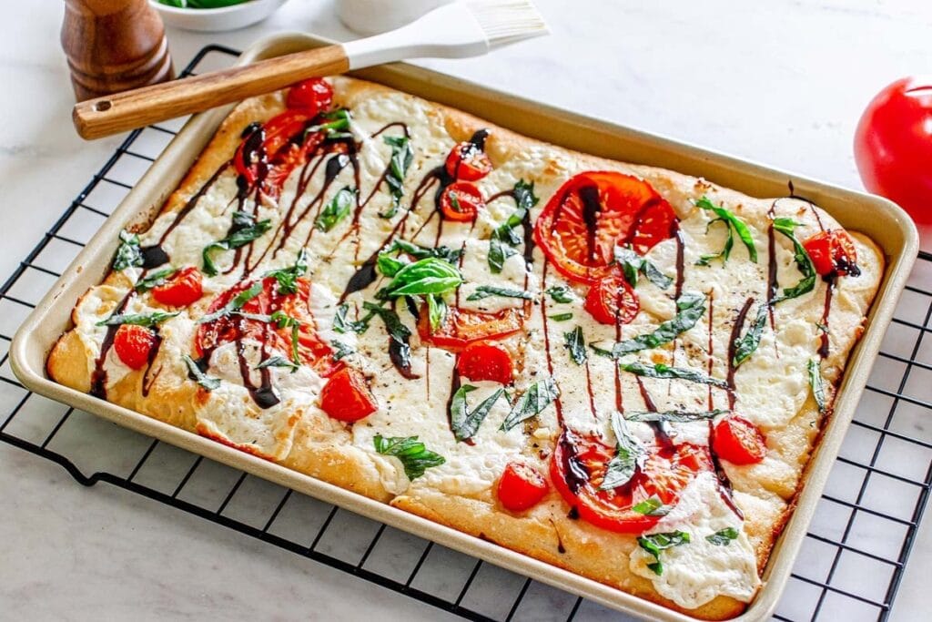 Caprese pizza on a sheet pan.