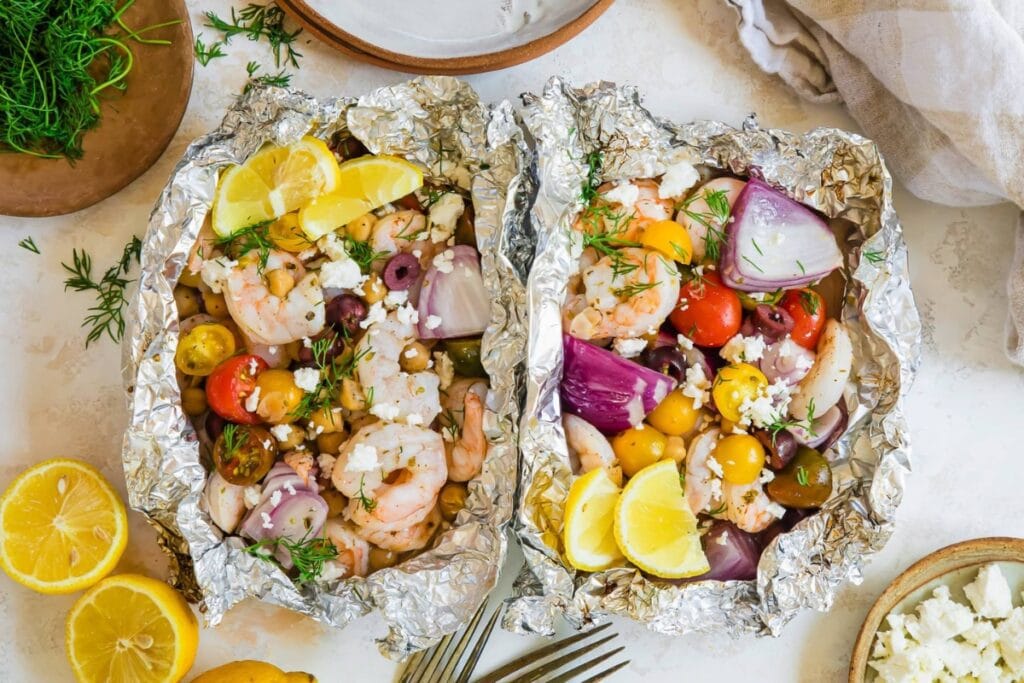 Shrimp foil packets with tomatoes, onions, and herbs.