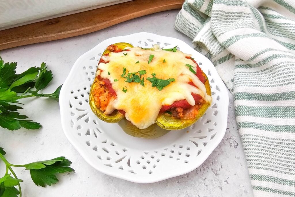 Stuffed bell peppers with melted cheese on a plate.
