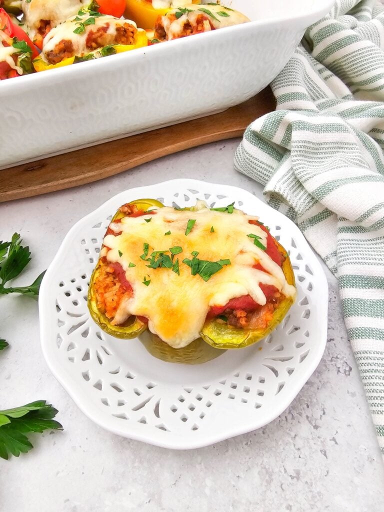 Stuffed bell peppers with melted cheese on a plate.