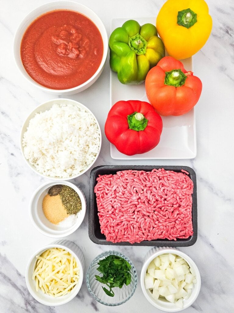 Stuffed peppers ingredients arranged on a white counter.