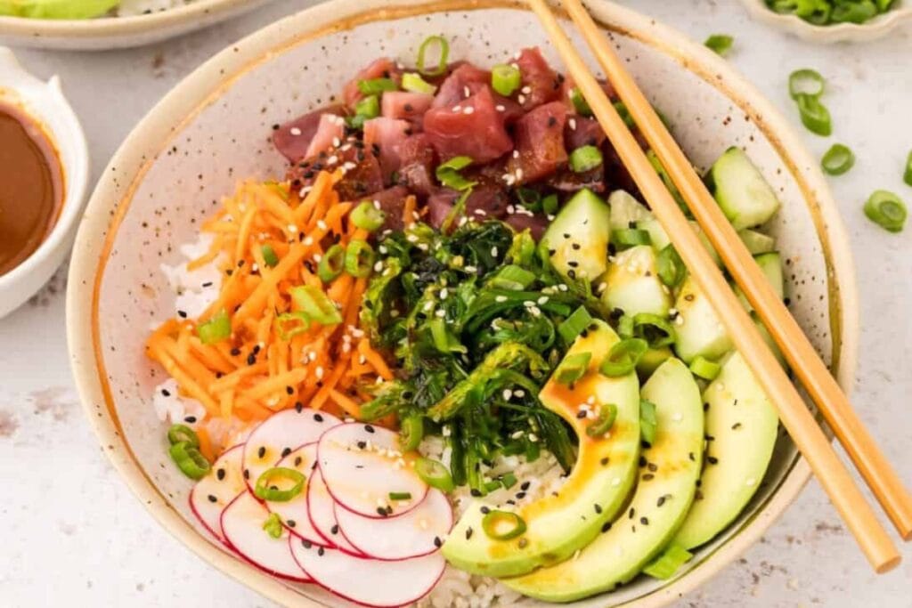 Tuna poke bowl with fresh vegetables and avocado in a bowl.